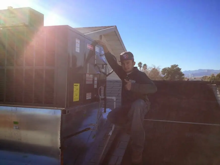 HVAC technician performing AC Tune-Up on a rooftop unit in Spokane